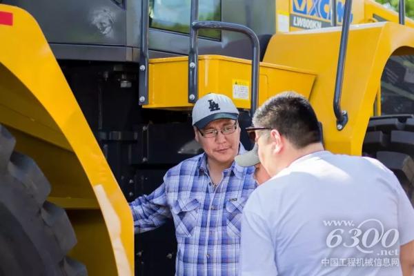 客戶仔細觀察裝載機，并不斷向工作人員詢問其性能參數